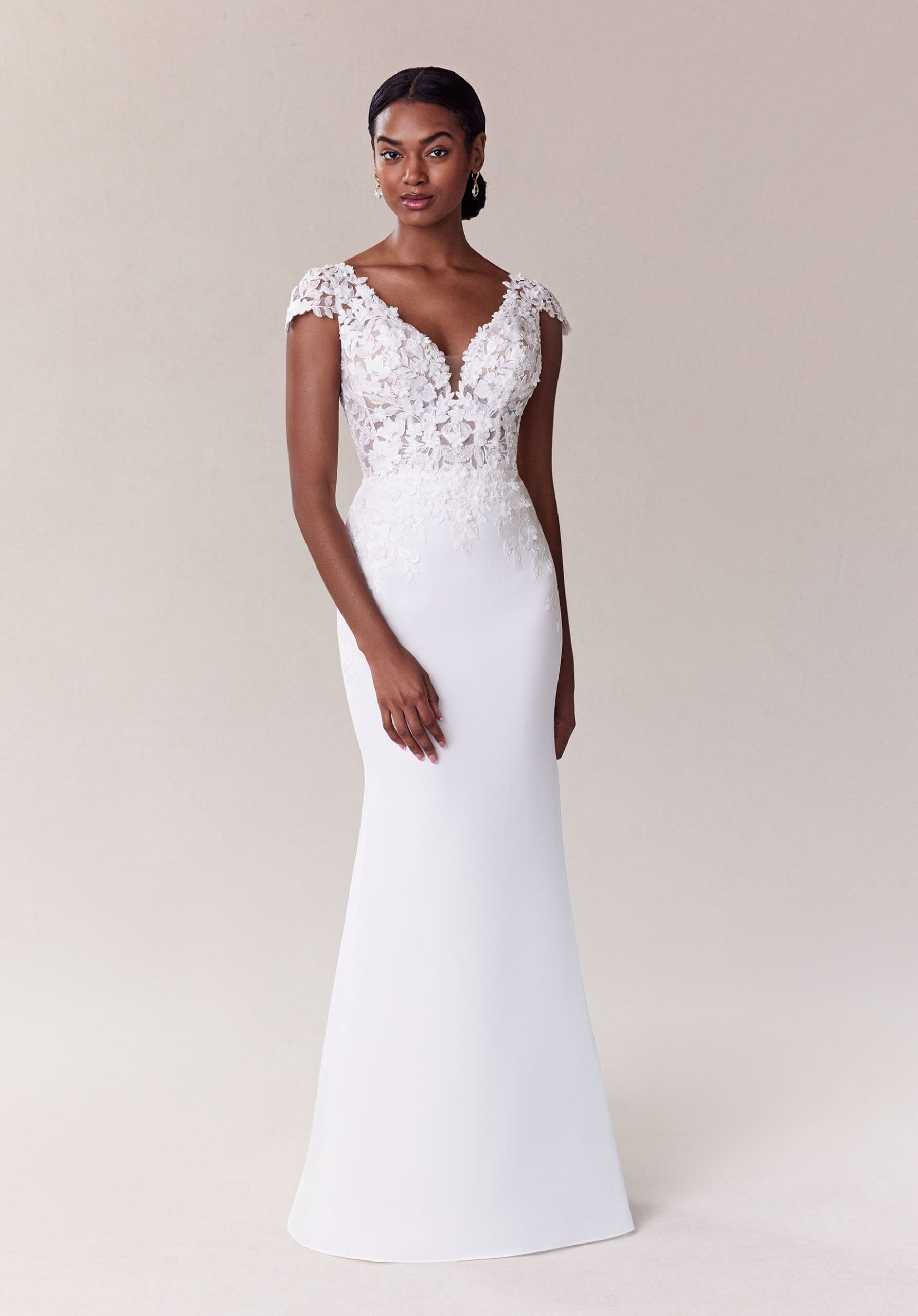 Fitted wedding dress with floral lace bodice, cap sleeves, deep V neckline and smooth crepe skirt