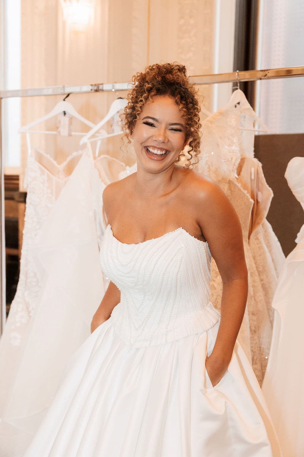 Bride laughing in her wedding dress. Scoop neckline and beaded bodice